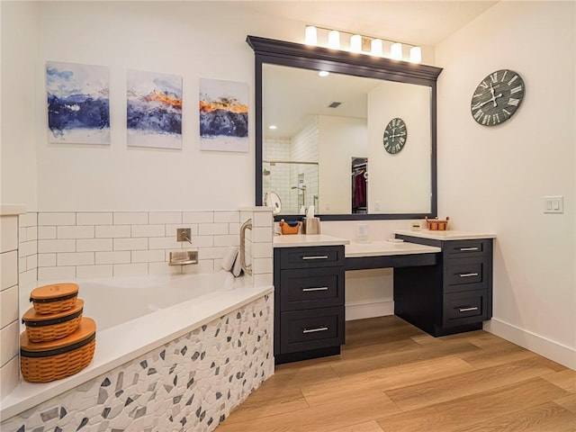 bathroom with separate shower and tub, vanity, and wood-type flooring