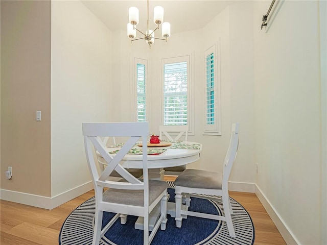 dining area featuring a notable chandelier, a barn door, and light hardwood / wood-style flooring