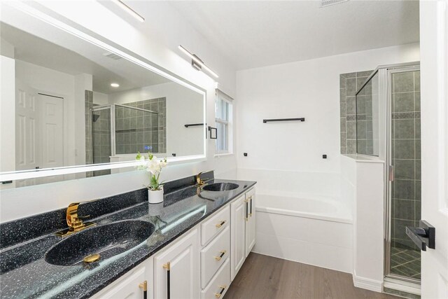 590 Valencia Cir SW, Vero Beach, FL 32968 - bathroom with a stall shower, wood finished floors, double vanity, and a garden tub