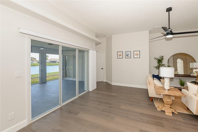 590 Valencia Cir SW, Vero Beach, FL 32968 - living room with wood finished floors, a ceiling fan, baseboards, a water view, and arched walkways