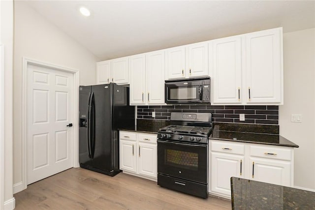 590 Valencia Cir SW, Vero Beach, FL 32968 - kitchen featuring black appliances, vaulted ceiling, decorative backsplash, white cabinetry, and light wood finished floors