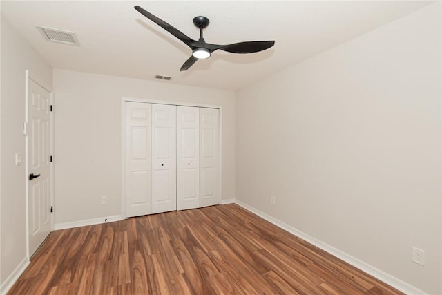 590 Valencia Cir SW, Vero Beach, FL 32968 - unfurnished bedroom with wood finished floors, baseboards, a closet, and a ceiling fan