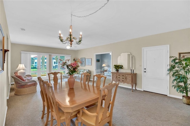 carpeted dining space featuring a chandelier and french doors