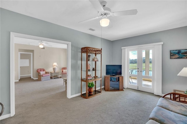 carpeted living room featuring french doors and ceiling fan