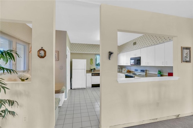 kitchen featuring white cabinetry, white appliances, and light tile patterned floors