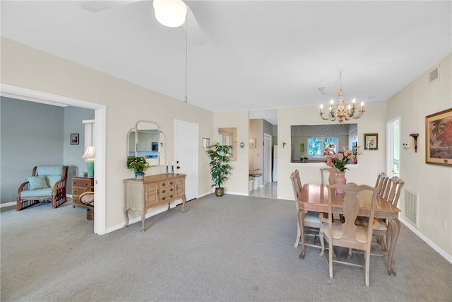 dining room featuring light carpet and a notable chandelier