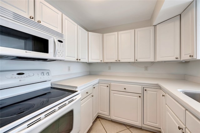 kitchen featuring white appliances, white cabinetry, and light tile patterned floors