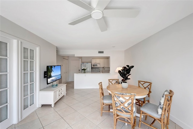 dining space featuring ceiling fan, sink, and light tile patterned floors