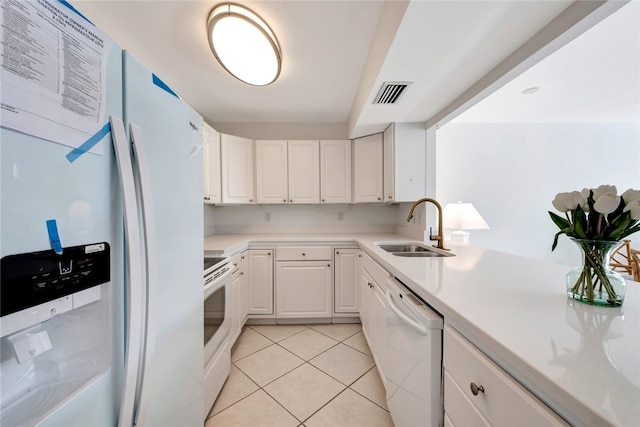 kitchen with light tile patterned floors, white appliances, white cabinetry, and sink