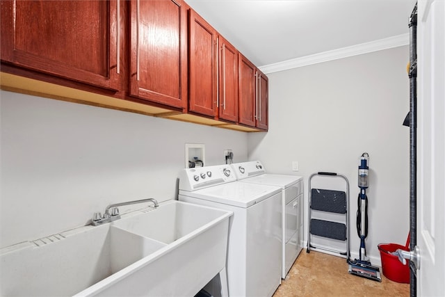 clothes washing area with ornamental molding, separate washer and dryer, cabinets, and sink