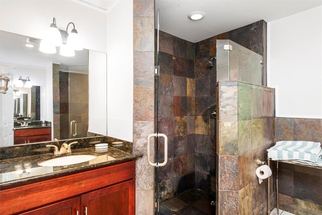 bathroom featuring tile walls, vanity, and a shower with door