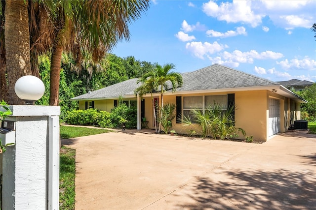 view of front of property with central AC unit and a garage