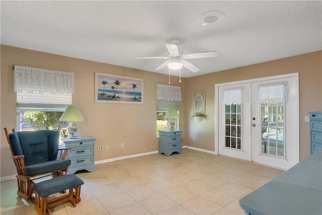 sitting room with french doors, light tile patterned floors, baseboards, and a ceiling fan