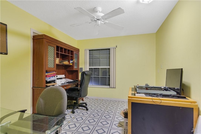 office space featuring ceiling fan and baseboards