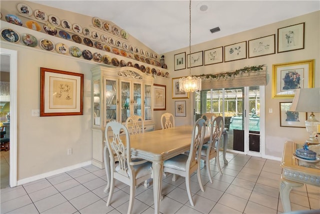 dining space with a notable chandelier, baseboards, vaulted ceiling, light tile patterned floors, and visible vents