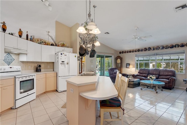 kitchen featuring white appliances, visible vents, under cabinet range hood, lofted ceiling, and open floor plan