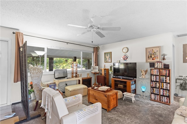 living room featuring carpet, ceiling fan, and a textured ceiling