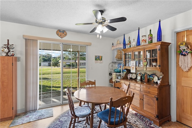 dining space featuring ceiling fan and a textured ceiling