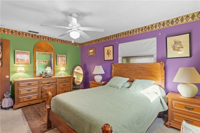 carpeted bedroom featuring a textured ceiling and ceiling fan