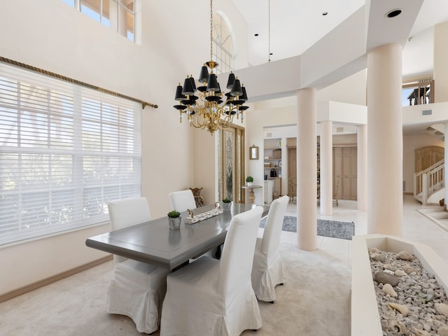 carpeted dining area with a notable chandelier, plenty of natural light, and a towering ceiling