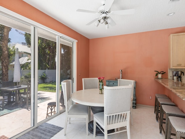 tiled dining space with ceiling fan