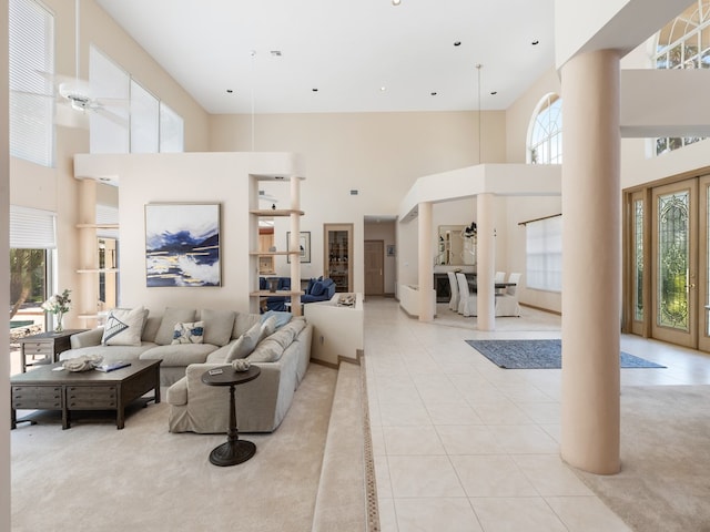 living room featuring plenty of natural light, a towering ceiling, and light tile patterned floors