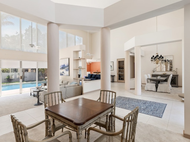 tiled dining room featuring ceiling fan and a towering ceiling