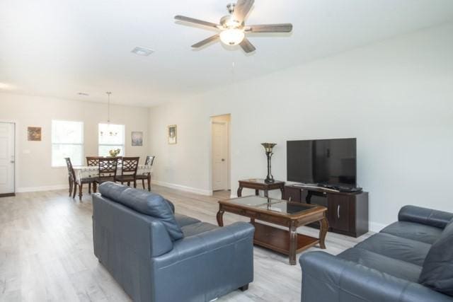 8286 96th Ct, Vero Beach, FL 32967 - living area featuring a ceiling fan, light wood finished floors, and baseboards