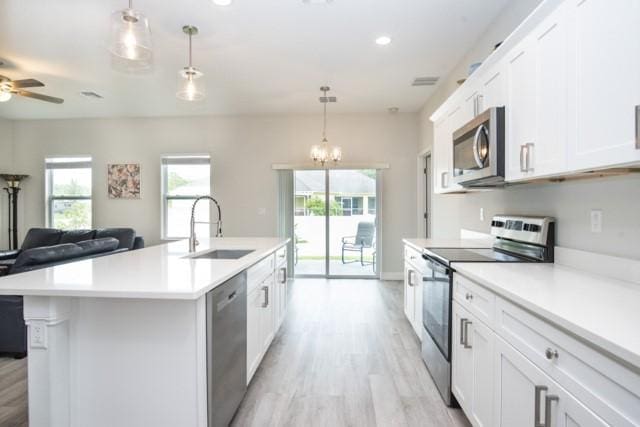 8286 96th Ct, Vero Beach, FL 32967 - kitchen with appliances with stainless steel finishes, a sink, light wood-style floors, light countertops, and recessed lighting