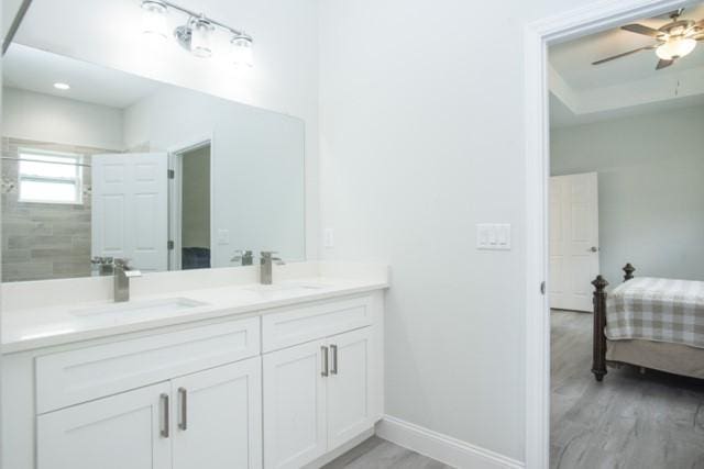 8286 96th Ct, Vero Beach, FL 32967 - ensuite bathroom featuring double vanity, baseboards, wood finished floors, and ceiling fan