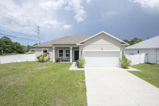 8286 96th Ct, Vero Beach, FL 32967 - ranch-style house with an attached garage and concrete driveway