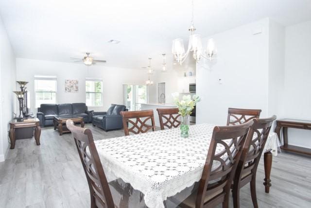 8286 96th Ct, Vero Beach, FL 32967 - dining area with light wood-type flooring, a chandelier, baseboards, and ceiling fan