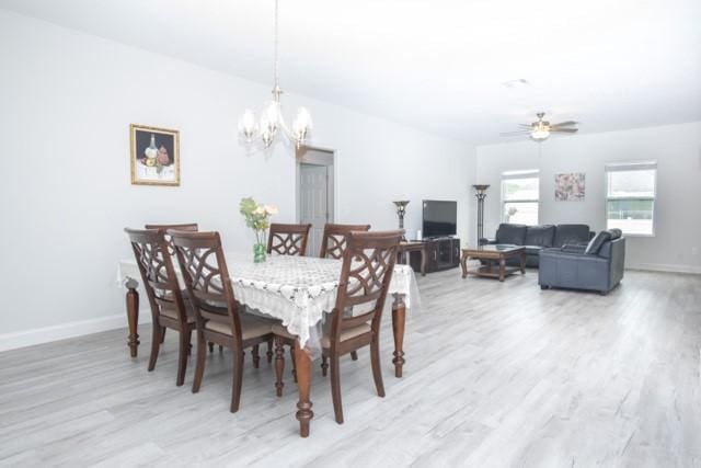 8286 96th Ct, Vero Beach, FL 32967 - dining room featuring light wood finished floors, a chandelier, baseboards, and ceiling fan