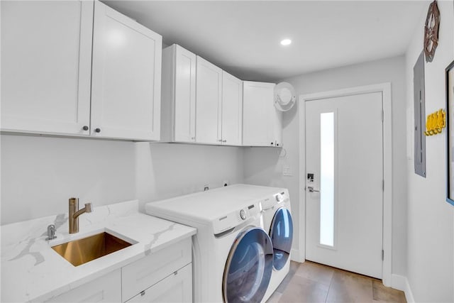 laundry area featuring cabinets, light tile patterned floors, separate washer and dryer, and sink