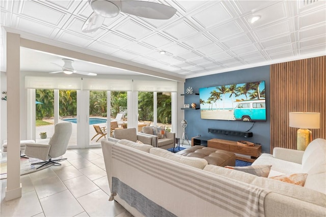 living room with a ceiling fan, a wealth of natural light, light tile patterned floors, and an ornate ceiling