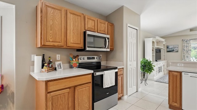 585 Birch Ct, Sebastian, FL 32958 - kitchen featuring light tile patterned floors, vaulted ceiling, appliances with stainless steel finishes, and light countertops