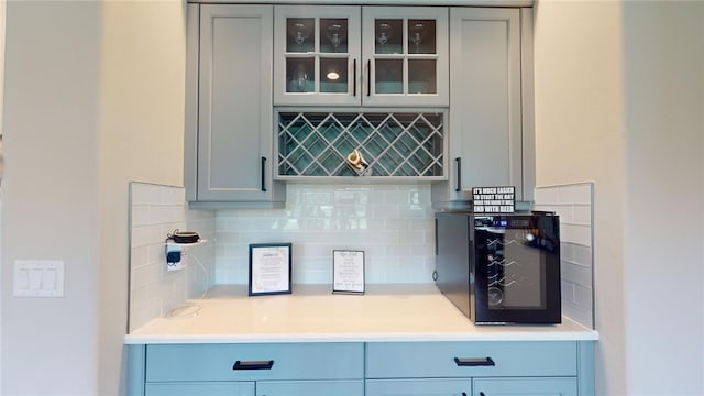 bar featuring gray cabinetry and backsplash