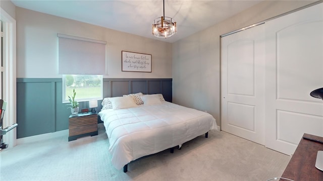 carpeted bedroom with a closet and a chandelier