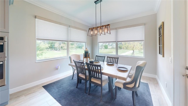 dining space with a wealth of natural light, light wood-type flooring, and ornamental molding