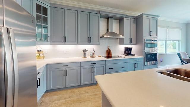 kitchen with tasteful backsplash, crown molding, stainless steel appliances, sink, and wall chimney exhaust hood