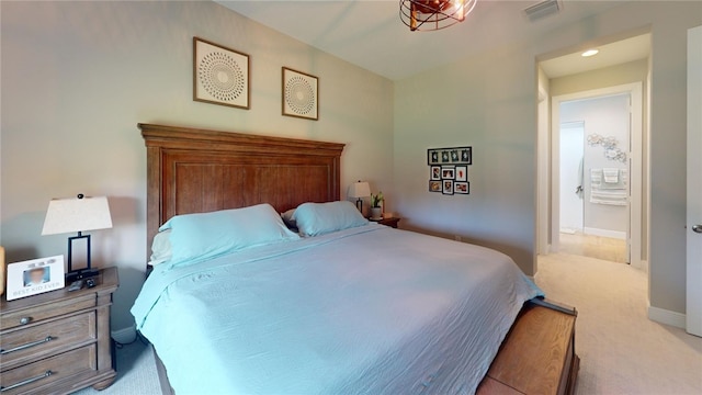 bedroom featuring light colored carpet and connected bathroom