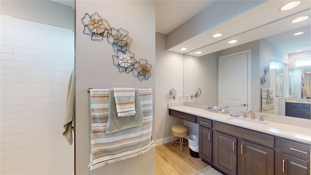 bathroom with a shower, wood-type flooring, and vanity