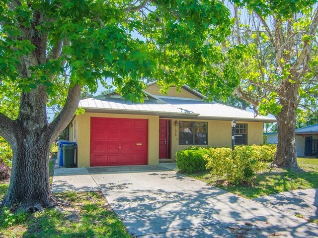 1626 4th Ct, Vero Beach, FL 32960 - view of front of home featuring a garage, stucco siding, and concrete driveway
