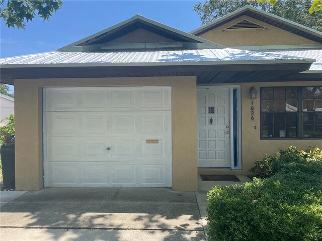1626 4th Ct, Vero Beach, FL 32960 - view of front of property featuring stucco siding, concrete driveway, metal roof, and a garage