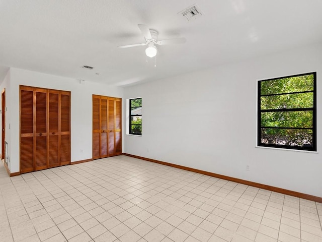 1626 4th Ct, Vero Beach, FL 32960 - unfurnished bedroom featuring two closets, baseboards, and a ceiling fan