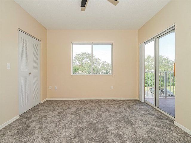 unfurnished bedroom featuring access to exterior, light carpet, a closet, and ceiling fan