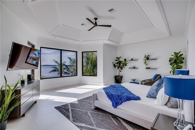 bedroom featuring light tile patterned floors, crown molding, and a tray ceiling