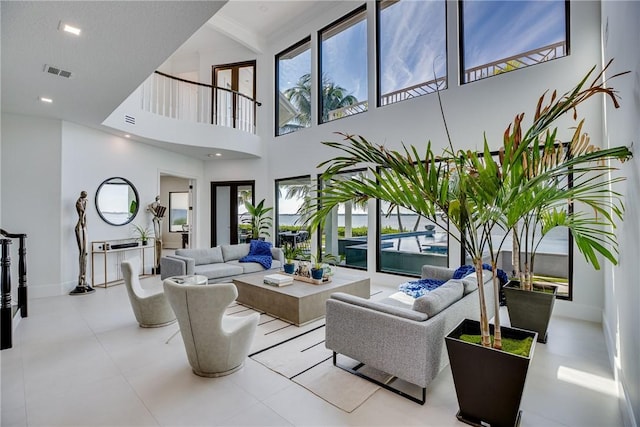 living room featuring a towering ceiling and a healthy amount of sunlight