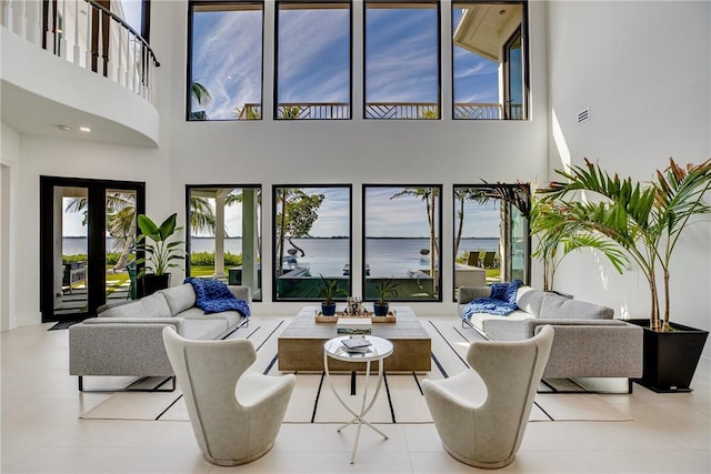 tiled living room featuring a high ceiling and french doors