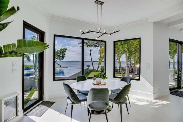 dining space with crown molding, a chandelier, and a water view